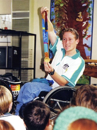 Richard Colman showing students at Campbell House his gold medal (T53 800 metres) from the Athens Paralympics. (Ad Astra Jan, 2008 Page 26)